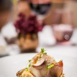 Tradicional bacalhau curado e aromatizado com limão e coentros, puré de grão de bico e chalotas caramelizadas