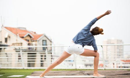 Beautiful woman doing yoga outdoors on a rooftop terrace