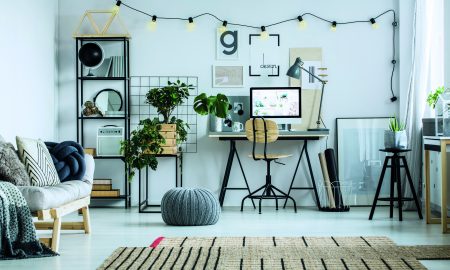 Designed carpet and grey pouf on glossy white floor. Home office design concept