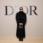 Rosalia vestiu um casaco preto Dior Fall-Winter 2024-2025 com uma saia preta de lã. Usou também uma carteira Dior, óculos de sol e botas. (Foto de Pascal Le Segretain/Getty Images for Christian Dior)