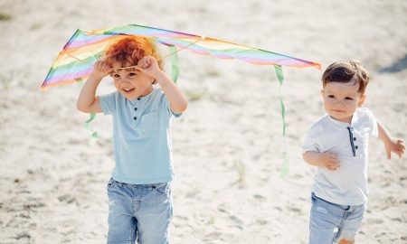 Little child in a summer field. Kids playing with a Kite