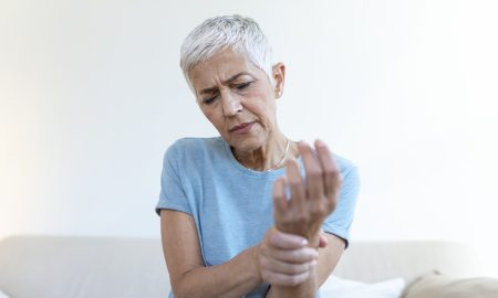 Elderly woman suffering from pain in hand, arthritis old person and senior woman female suffering from pain at home