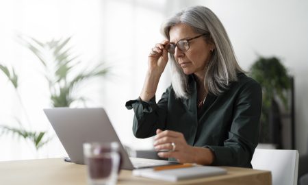 mulher-velha-de-tiro-medio-trabalhando-no-laptop-dentro